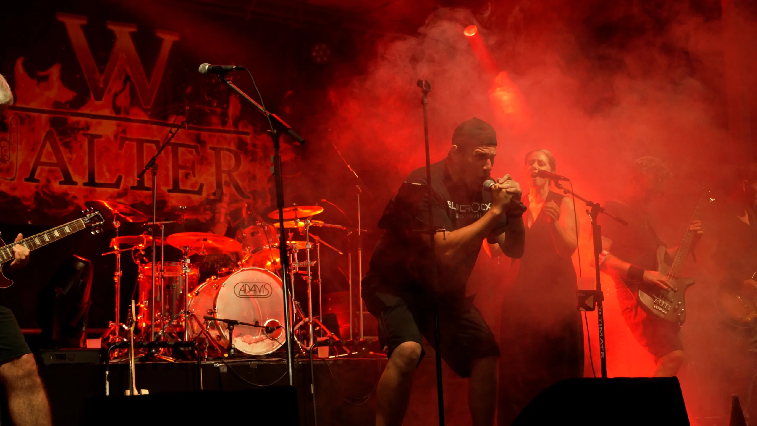 Lebendige Eventfotografie von ArsMotion: Emotionale Aufnahmen eines Live-Konzerts mit roter Bühnenbeleuchtung für professionelle Eventdokumentationen