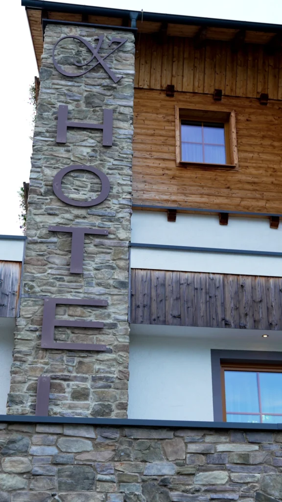 Moderne Hotelfassade des Hotel Kornock mit markantem Steinpfeiler und Holz-Elementen auf der Turracher Höhe
