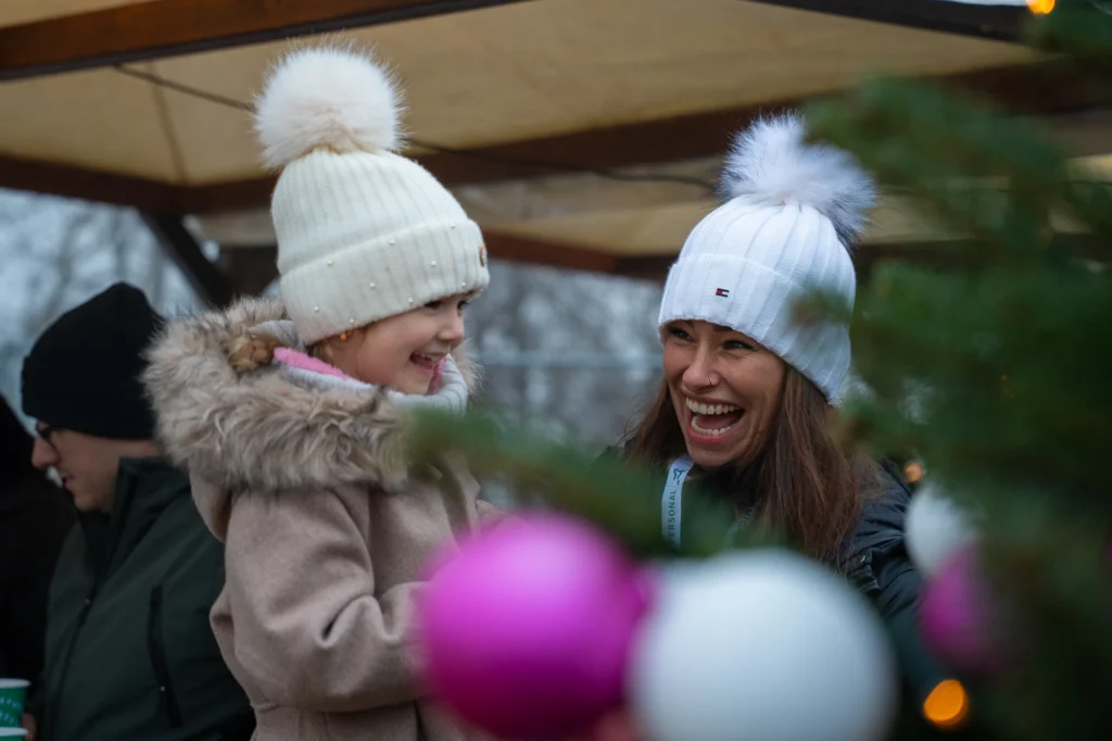 Familienfreundliche Firmenfeier in Baden: Fröhliche Gäste mit Wintermützen genießen die Atmosphäre beim Dynamic Personal Weihnachtsevent.