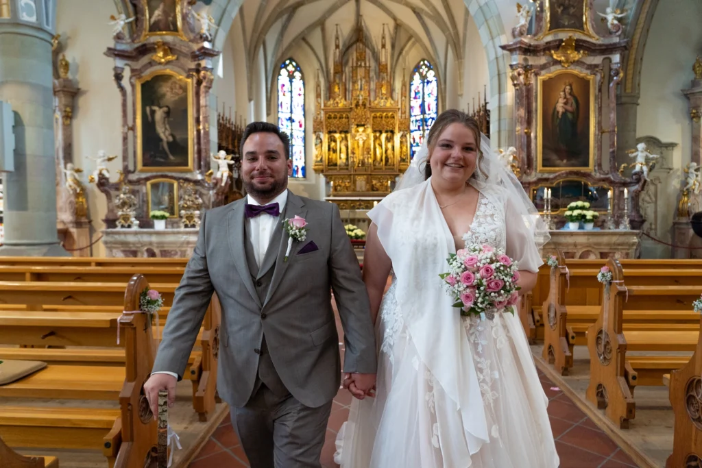 Der feierliche Auszug aus der Kirche: Das frisch vermählte Paar Eileen und Patrick verlässt die barocke Kirche in Wangen im Allgäu.