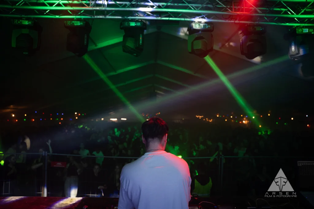 Die Perspektive von Niklas Dee: Beeindruckender Crowd-Shot von hunderten feiernden Gästen unter Laser-Licht beim Greenfield 2025.