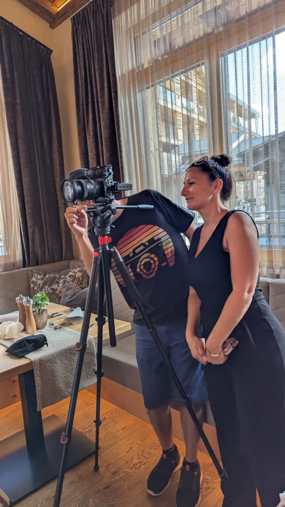 Qualitätssicherung am Set: Videoproduzent zeigt der Kundin die fertigen Videoaufnahmen im Hotel Kornock