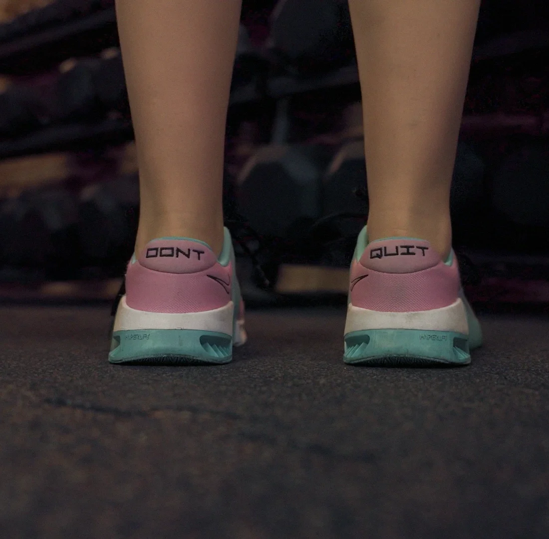 Detailaufnahme von Sportschuhen mit der motivierenden Aufschrift Dont Quit auf den Fersen