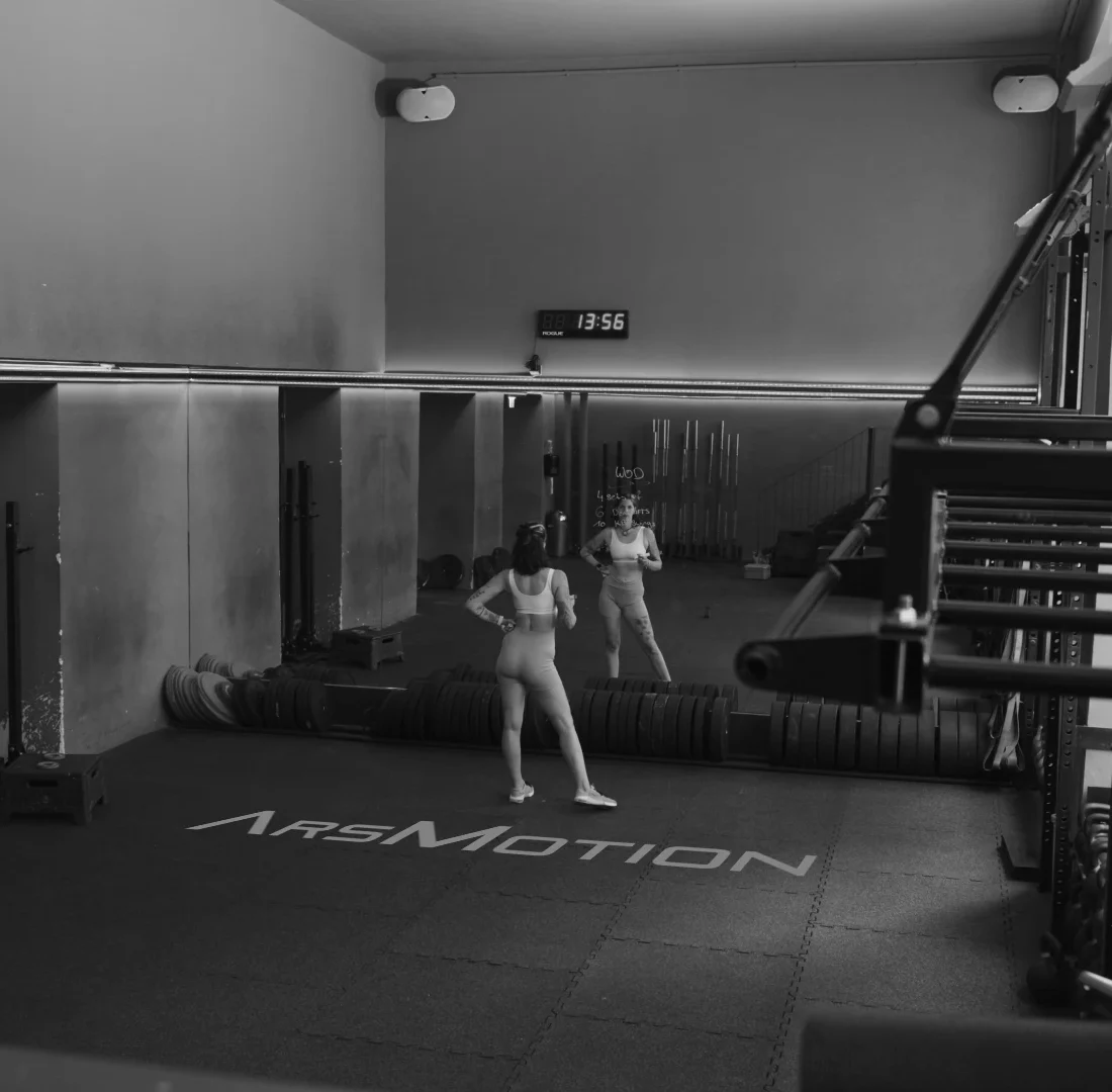 Weitwinkel Schwarz-Weiß Fotografie der Trainingsfläche mit ArsMotion Logo Branding auf dem Boden