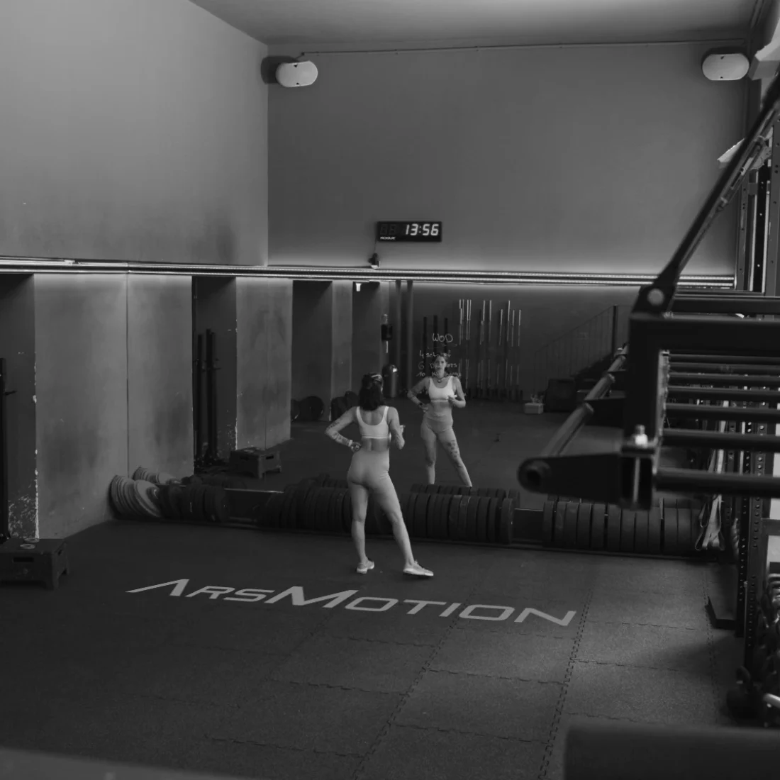 Weitwinkel Schwarz-Weiß Fotografie der Trainingsfläche mit ArsMotion Logo Branding auf dem Boden