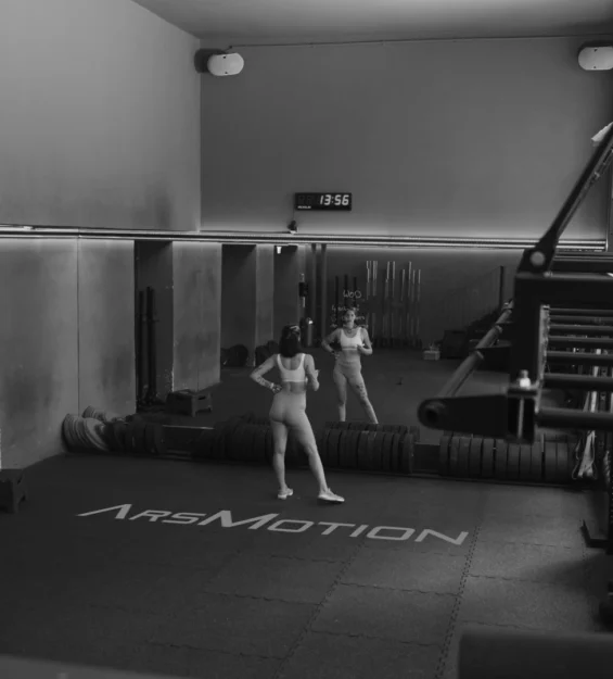 Weitwinkel Schwarz-Weiß Fotografie der Trainingsfläche mit ArsMotion Logo Branding auf dem Boden