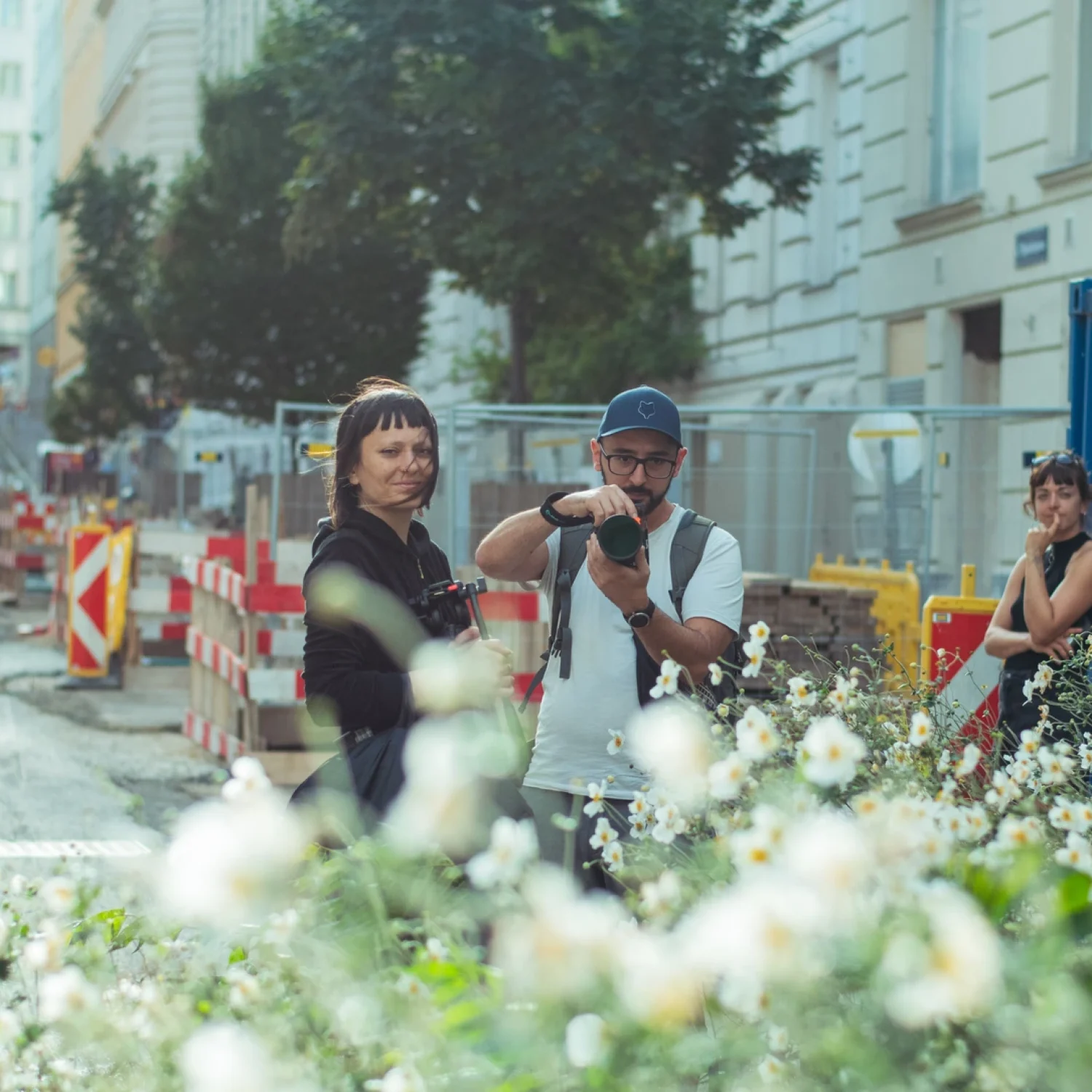Das Produktionsteam von ArsMotion am Set der Laura Gruener Naiv Fashion Kampagne hinter weißen Blumen in Wien