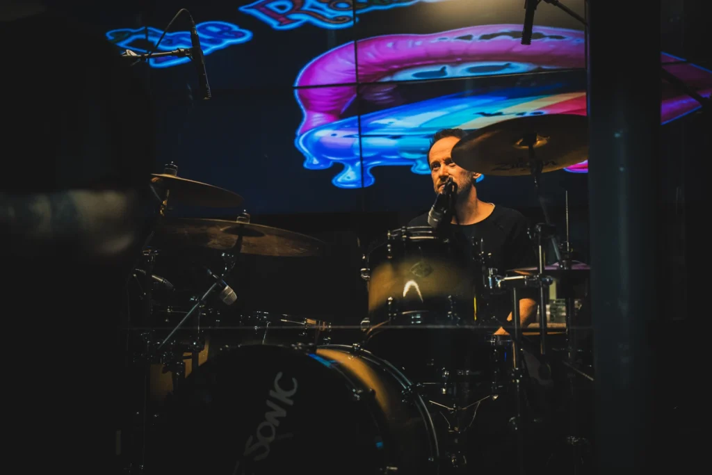 Energetische Schlagzeug-Performance: Drummer in Action beim RainbowKissers Konzert, festgehalten mit kurzer Verschlusszeit.