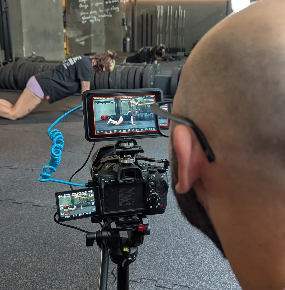 Blick über die Schulter des Kameramanns auf den Monitor der Sony Kamera während einer Aufnahme von Ines Gruber am Boden